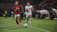 Gelandang Bali United, Mohammed Rashid, berduel dengan winger Madura United, Lulinha. (Bola.com/Alit Binawan).