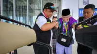 Petugas tengah menolong jemaah haji saat akan menaiki buggy car di Bandara Madinah. (Liputan6.com/Nafiysul Qodar)