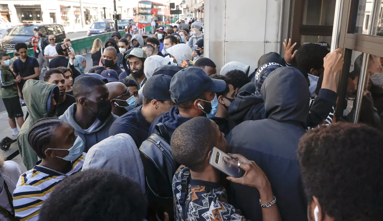 Antrean orang-orang untuk memasuki toko Niketown di London, Senin (15/6/2020). Antrean panjang terjadi di luar toko-toko yang berada di sejumlah kota di Inggris saat negara itu melakukan pelonggaran lockdown dan mulai membuka pusat perbelanjaan. (AP/Matt Dunham)
