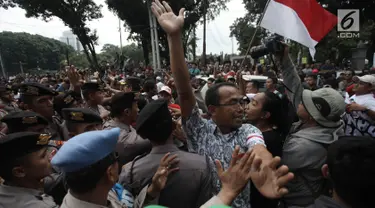 Demonstran driver online saling dorong dengan pihak kepolisian saat unjuk rasa di depan Istana Negara, Jakarta, Rabu (14/2). Kericuhan nyaris terjadi lantaran demonstran mencegat para driver online yang masih beroperasi. (Liputan6.com/Arya Manggala)