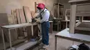 Tukang kayu Iran Sahar Biglari mengampelas sebatang kayu saat bekerja di bengkelnya di Teheran, Iran, 12 Maret 2023. Sahar, mantan guru matematika dan fisika di Iran telah mendobrak tabu untuk menjadi tukang kayu selebritas. (AP Photo/Vahid Salemi)
