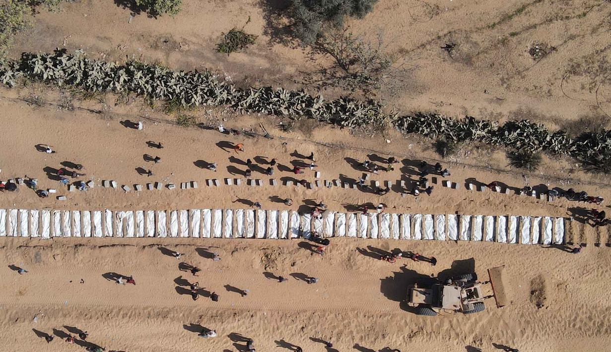 Foto udara menunjukkan warga Palestina memakamkan 54 jenazah yang tidak teridentifikasi di sebuah pemakaman di Deir al-Balah, di bagian tengah Jalur Gaza, pada 22 Oktober 2025. (Foto oleh AFP)