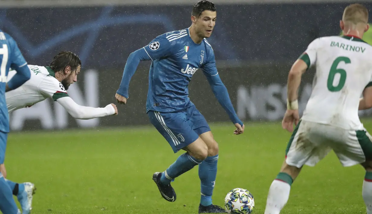 Penyerang Juventus, Cristiano Ronaldo menggiring bola dari kawalan pemain Lokomotiv Moscow, Dmitri Barinov dan Grzegorz Krychowiak pada pertandingan Grup D Liga Champions di stadion RZD Arena, Moskow (6/11/2019). Juventus menang 2-1 atas Lokomotiv Moscow. (AP Photo/Pavel Golovkin)