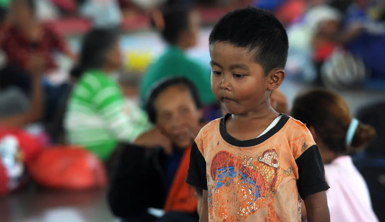 Seorang anak laki-laki berdiri di tempat penampungan sementara di Kabupaten Klungkung, Bali (22/9). Pengungsi tercatat berada di pos pengungsi GOR Swecaparu Kecamatan Klungkung, Kabupaten Klungkung sebanyak 378 jiwa. (AFP Photo/Sonny Tumbelaka)