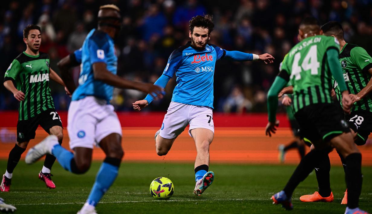 Pemain Napoli, Khvicha Kvaratskhelia (tengah) menendang bola ke gawang Sassuolo yang membuahkan gol dalam pertandingan pekan ke-23 Liga Italia 2022/2023 di Mapei Stadium, Sabtu (18/2/2023). (AFP/Marco Bertorello)