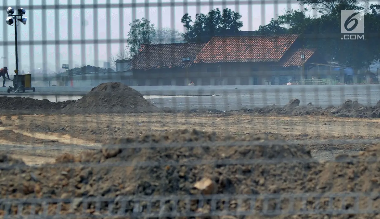 Pekerja menyelesaikan proyek perluasan landasan pacu atau Runway 3A Bandara Soekarno-Hatta di kawasan Rawa Rengas, Kosambi, Tangerang, Banten, Selasa (2/7/2019). Sekitar 130 KK masih bertahan di rumahnya karena belum menerima ganti rugi dari proyek tersebut. (merdeka.com/Arie Basuki)