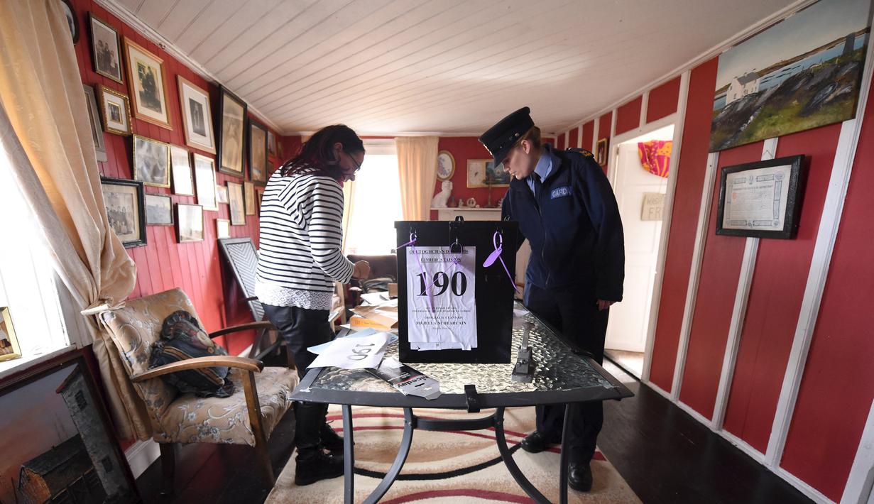 Polwan Margaret Byrne menyiapkan kotak suara pemilu di sebuah rumah warga, di Inishfree, sebuah pulau terpencil di lepas pantai Donegal, Irlandia, Kamis (25/2). Irlandia akan menggelar pemilu pada 26 Februari. (REUTERS/Clodagh Kilcoyne)