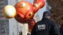 Petugas Kepolisian Kota New York mengawasi mengawasi Parade Thanksgiving Day di New York City (26/11/2015). Beragam balon raksaksa yang dibuat seperti tokoh animasi menjadi suguhan utama dalam perayaan tersebut. (AFP Photo/Timothy A. Clary)
