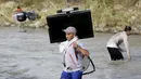 Seorang pria membawa televisi saat melintasi perbatasan sungai Tachira dengan Venezuela ke Kolombia, di Villa del Rosario (25/8/2015). Sebanyak 1.012 warga Kolombia dideportasi dari Venezuela. (REUTERS/Jose Miguel Gomez)