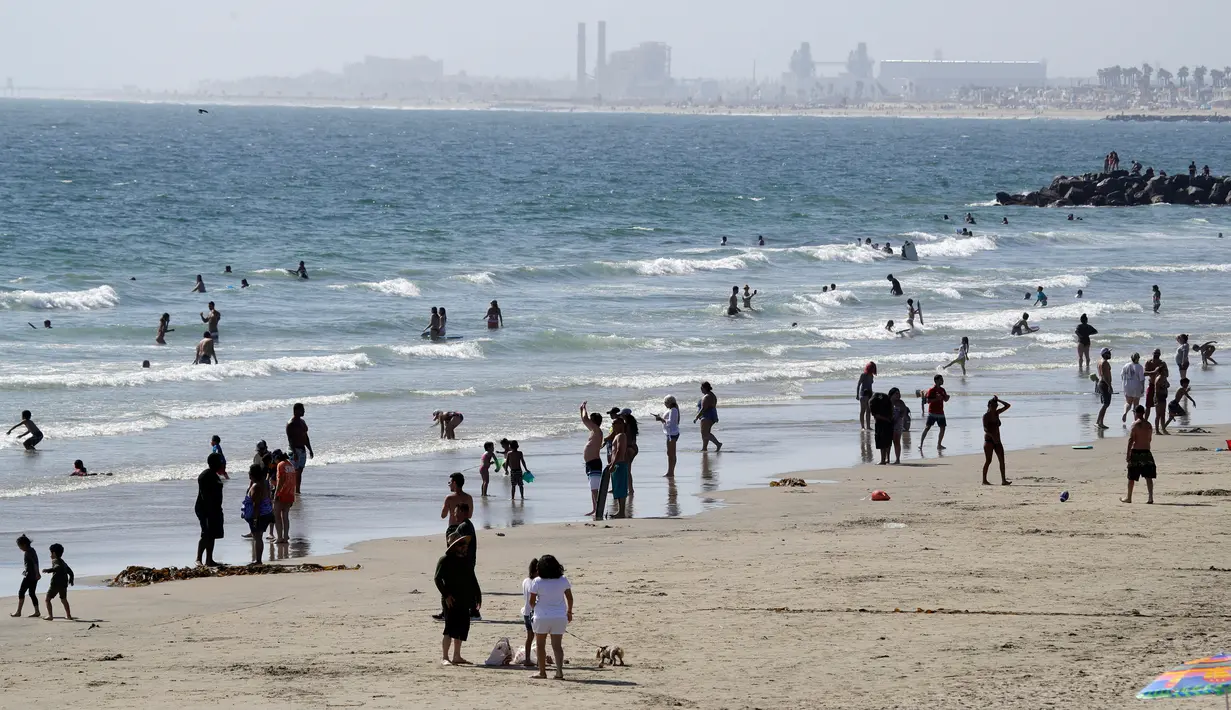 Orang-orang mengunjungi Pantai Newport selama masa pandemi covid-19 di California pada Minggu (24/5/2020). Warga Amerika Serikat mengabaikan pedoman jarak sosial dan memilih berjemur di pantai ketika angka kematian akibat virus corona di negara itu mendekati 100.000 orang. (AP/Marcio Jose Sanchez)