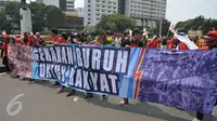 Massa aksi Hari Buruh membawa spanduk saat memperingati Hari Buruh Internasional di Jakarta, Senin (1/5). Dalam aksinya para buruh meminta sistem kerja kontrak dan upah rendah dihapus. (Liputan6.com/Helmi Afandi)