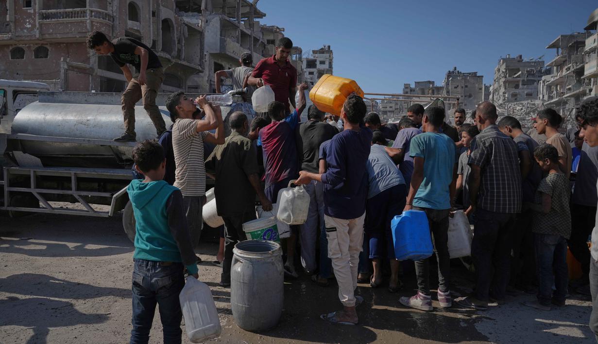 Warga, termasuk anak-anak, sering kali harus mengantre berjam-jam untuk mendapatkan air. Jumlah air yang didapat pun sangat terbatas, jauh dari cukup untuk kebutuhan normal. (AP Photo/Jehad Alshrafi)