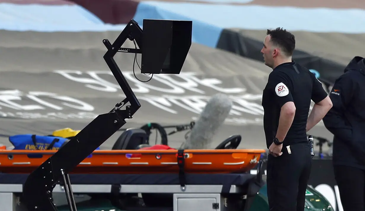 Wasit Chris Kavanagh menonton monitor VAR selama pertandingan Liga Inggris antara West Ham United dan Chelsea di London Stadium, London, Inggris, Sabtu (24/4/2021). Chelsea menang 1-0. (AP Photo/Alastair Grant, Pool)