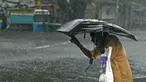 Seorang pejalan kaki menyeberangi jalan yang tergenang air setelah hujan lebat di Chennai, kawasan Teluk Benggala, Timur India pada 4 Desember 2023. (R. Satish BABU/AFP)