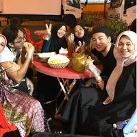 Laudya Cynthia Bella menggandeng mesra suaminya, Engku Emran yang sedang memakan duren. (Instagram @laudyacynthiabella)