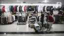 Dua orang pria menata pakaian impor bekas di Metro Atom Pasar Baru, Jakarta, Selasa (19/7/2022). Wakil Ketua DPR RI Bidang Korinbang Rachmat Gobel menyayangkan Indonesia masih melakukan impor pakaian bekas. (Liputan6.com/Faizal Fanani)