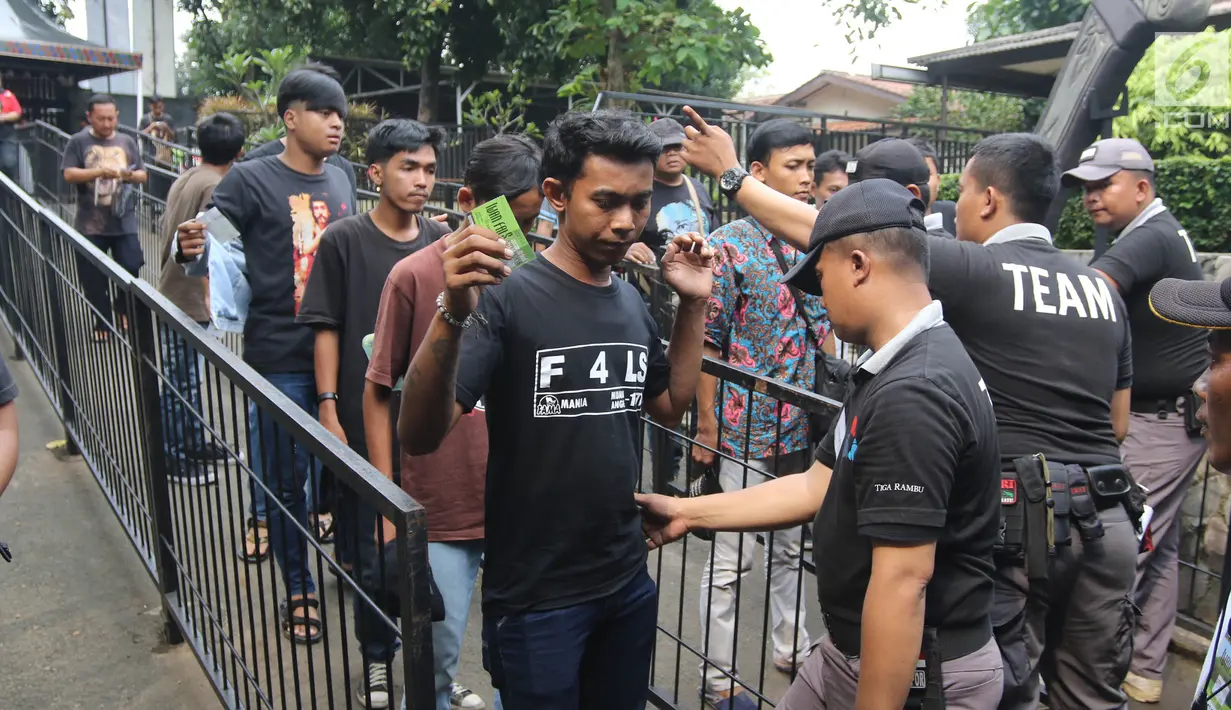 Petugas memeriksa penonton sebelum memasuki area Konser Situs Budaya Iwan Fals dan Band di Panggung Kita, Depok, Sabtu (3/3). Konser Situs Budaya ini mengangkat budaya dari NTB Kerajaan Lombok dan Bima. (Liputan6.com/Arya Manggala)