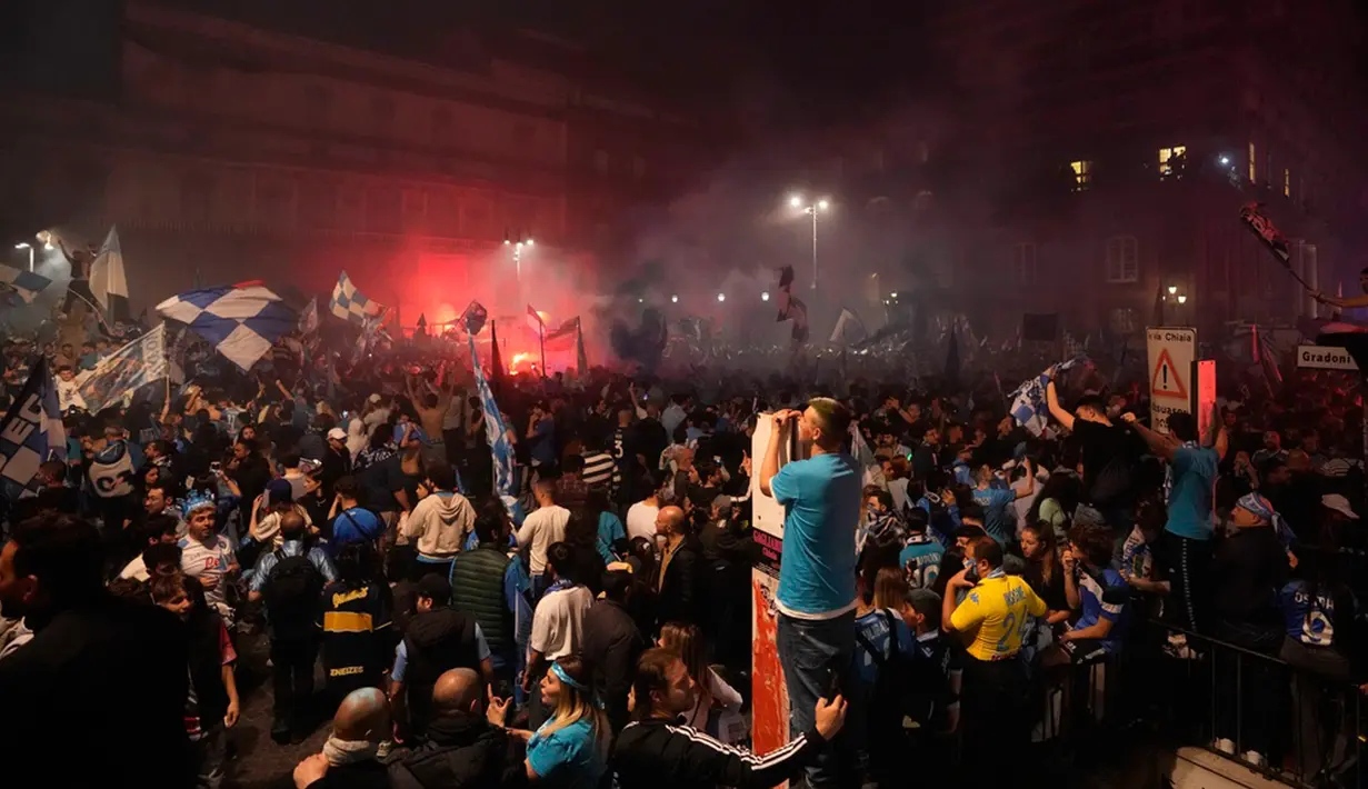 Ada pula pemuda yang terjun ke kolam air mancur seraya berteriak kegirangan, sementara lainnya mengibarkan bendera besar Napoli. (AP Photo/Andrew Medichini)