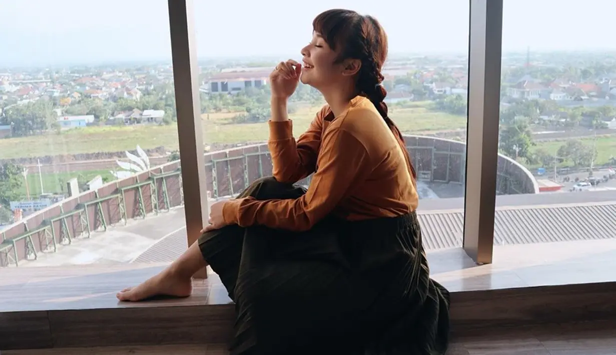 Menggunakan pakaian berwarna kuning dan rok hitam, penyanyi tembang 'Kasmaran' ini tampak sangat cantik. Dengan rambut yang dikepang ke belakang, ia berpose dengan bahagia dengan senyumannya yang manis. (Liputan6.com/IG/@tasya_ratu_gopo)