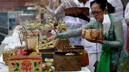 Umat Hindu melakukan persembahan kehadapan Sang Hyang Widi dan dewa atau bhatara sebagai tanda puji syukur serta permohonan untuk keselamatan. (Photo by SONNY TUMBELAKA / AFP)