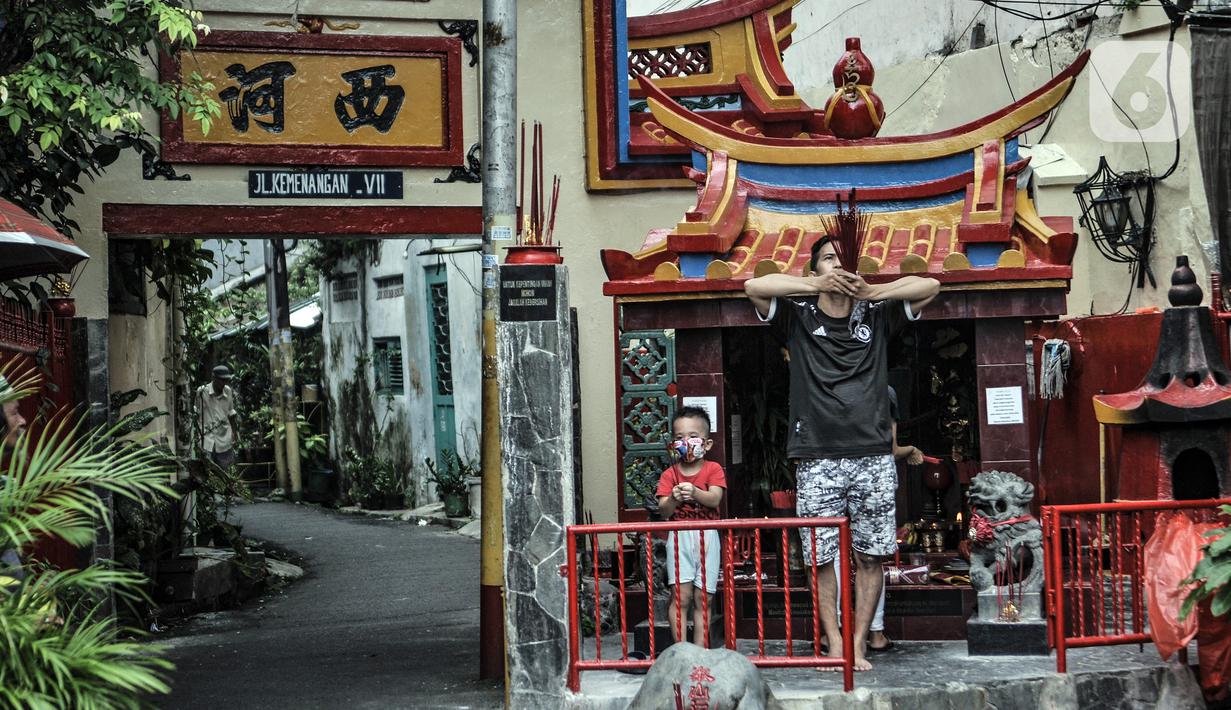 Warga keturunan Tionghoa sembahyang malam Tahun Baru Imlek 2572 di luar klenteng kawasan Petak Sembilan, Glodok, Jakarta, Kamis (11/2/2021). Pihak klenteng juga memberikan sistem nomor antrean pada sembahyang malam Imlek kali ini. (merdeka.com/Iqbal S. Nugroho)