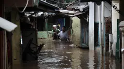 Warga melintasi banjir di Jalan Kebon Pala, Kampung Melayu, Jatinegara, Jakarta Timur, Rabu (7/2). Setelah sempat surut, banjir kembali merendam permukiman warga dengan ketinggian air mencapai sekitar 170 cm. (Liputan6.com/Arya Manggala)