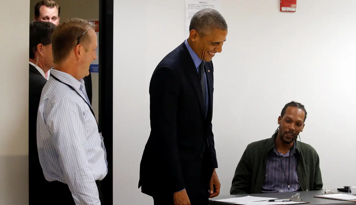 Presiden AS Barack Obama tersenyum ketika berbincang dengan pekerja jajak pendapat di TPS awal di Chicago, Illinois, Jumat (7/10). Obama memberikan suaranya lebih dahulu untuk Pilpres AS pada 8 November 2016 mendatang. (REUTERS/Jonathan Ernst)