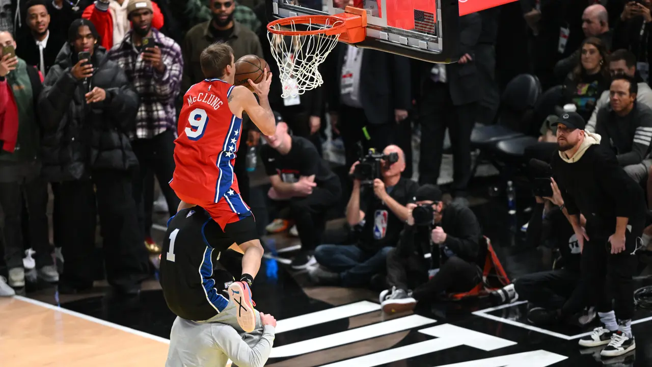 Mac McClung melompati dua orang yang bergendongan di kontes slam dunk NBA All-Star 2023