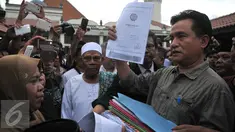 Yusril Izha Mahendra menerima satu bundel surat-surat dari warga Kampung Luar Batang, Jakarta, Rabu (6/4). Yusril akan mendampingi warga Kampung Luar Batang untuk menolak rencana revitalisasi Pemprov DKI Jakarta. (Liputan6.com/Gempur M Surya) 