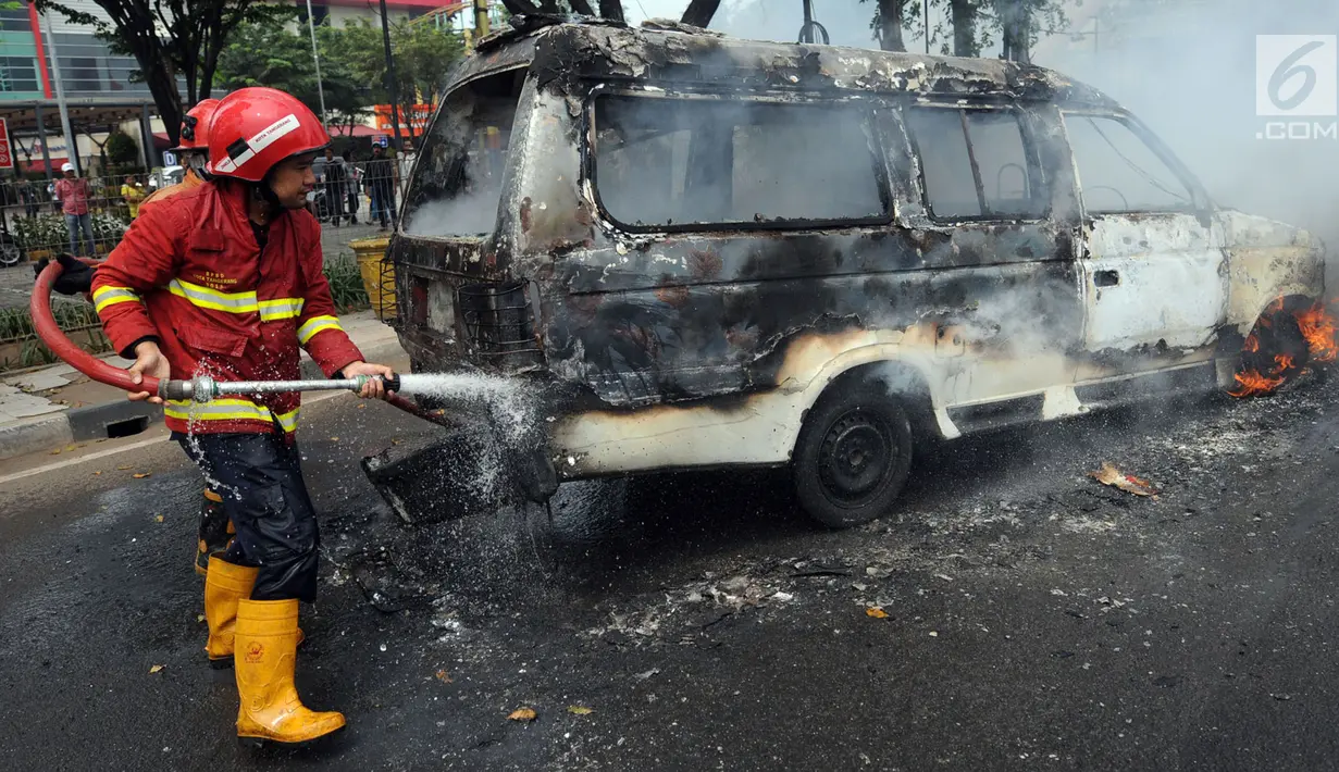 Petugas pemadam kebakaran berusaha memadamkan api yang menghanguskan angkutan kota (angkot) jurusan Ciledug-Cipete di kawasan Kebun Nanas, Tangerang, Kamis (17/5). Kebakaran diduga terjadi akibat hubungan arus pendek kabel aki. (Merdeka.com/Arie Basuki)