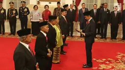 Presiden Joko Widodo memberikan tanda jasa kepada ahli waris dalam penganugerahan gelar Pahlawan Nasional di Istana Negara, Jakarta, Kakis (8/11).  Jokowi menganugerahkan gelar pahlawan nasional kepada enam tokoh. (Liputan6.com/Angga Yuniar)