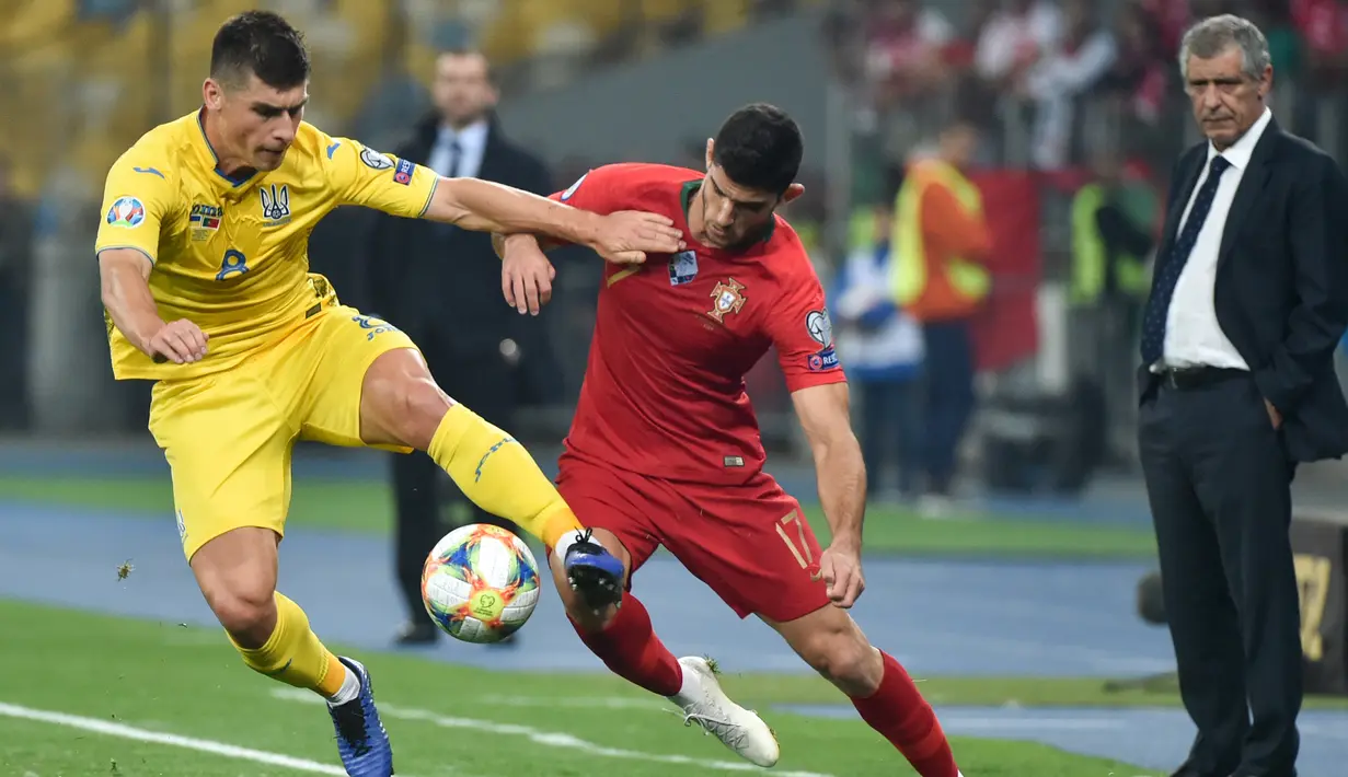 Gelandang Ukraina, Ruslan Malinovskyi berebut bola dengan striker Portugal, Goncalo Guedes selama pertandingan Grup B Kualifikasi Piala Eropa 2020 di Stadion NSK Olympiyskiy (15/10/2019). Dengan kemenangan ini, Ukraina lolos ke putaran final Piala Eropa 2020 dari grup B. (AFP Photo/Genya Savilov)