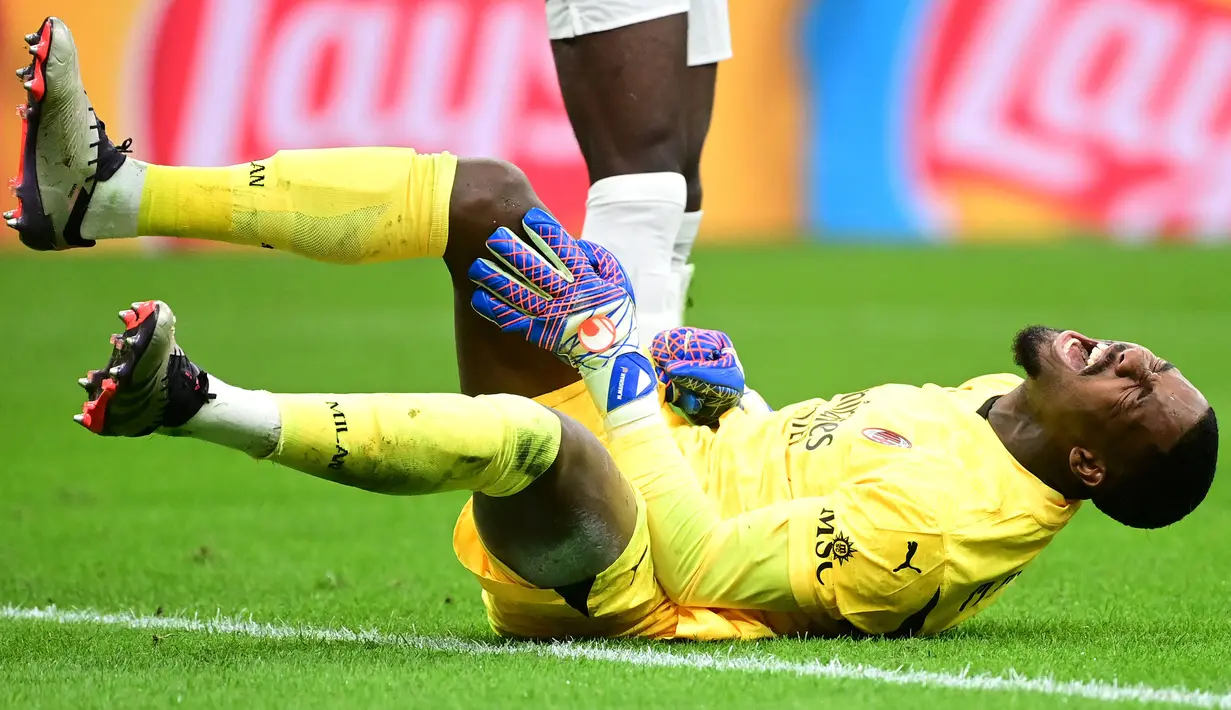 Maignan pun tak mampu menutupi rasa kesakitannya setelah mengalami benturan. Kiper asal Prancis tersebut kemudian ditarik ke luar untuk digantikan dengan Lorenzo Torriani pada menit ke-51. (AFP/Piero Cruciatti)