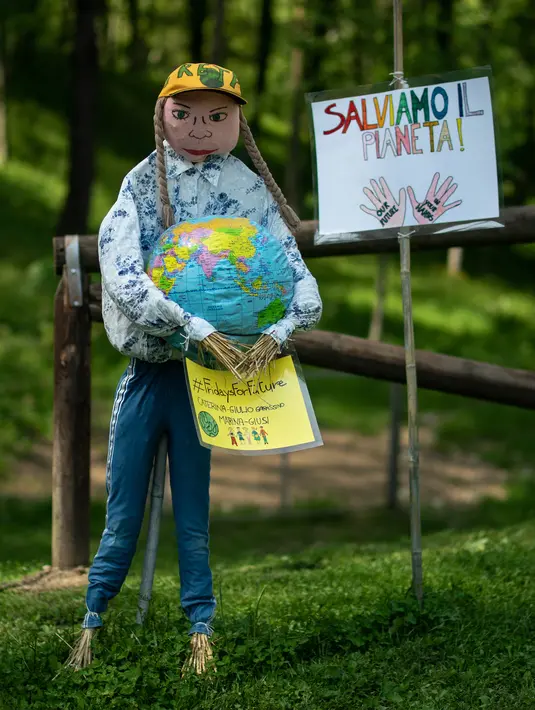 Orang-orangan sawah yang menggambarkan juru kampanye lingkungan Swedia, Greta Thunberg, ditampilkan selama "Scarecrows Fair"di Castellar, distrik Provinsi Cuneo, Italia, 10 Mei 2019. Dalam acara tahunan tersebut, penduduk membuat orang-orangan sawah kreasi mereka sendiri. (MARCO BERTORELLO/AFP)