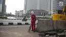 Pekerja dibantu alat berat merevitalisasi trotoar di kawasan Bundaran HI, Jakarta Pusat, Senin (15/7/2019). Penantaan ini dilakukan untuk mempercantik trotoar dan memberikan rasa nyaman bagi pejalan kaki. (Liputan6.com/Faizal Fanani)