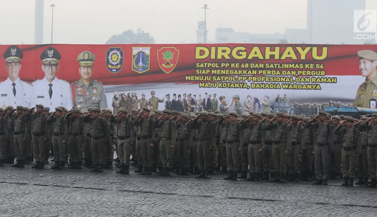 Satuan Polisi Pamong Praja (Satpol PP) memberikan hormat ketika upacara peringatan HUT Satpol PP ke-68 di Monas, Jakarta, Kamis (26/4). Dalam HUT Satpol PP itu, Gubernur DKI Anies Baswedan bertindak sebagai Inspektur Upacara. (Liputan6.com/Arya Manggala)
