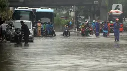 Pengendara antre melintasi Jalan Di Panjaitan dekat Halte Transjakarta Cawang Soetoyo yang banjir, Jakarta, Rabu (1/1/2020). Hujan yang mengguyur Jakarta sejak Selasa sore (31/12/2019) mengakibatkan banjir di sejumlah titik di Jakarta. (Liputan6.com/Helmi Fithriansyah)