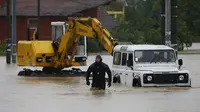 Seorang polisi Serbia melintasi banjir di Kota Lazarevac, sebelah selatan Belgrade. (Reuters/Marko Djurica)