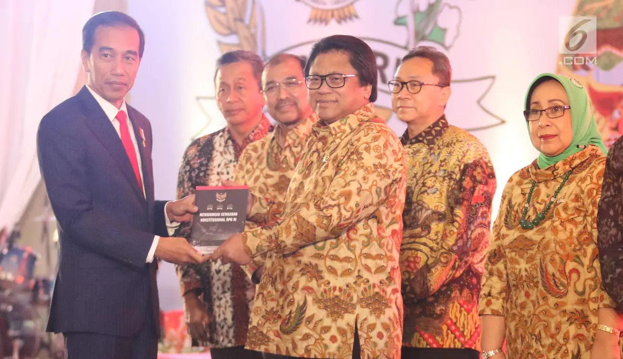 Presiden Joko Widodo menerima buku dari Ketua DPD Oesman Sapta Odang saat acara Sarasehan Nasional DPD RI di Senayan, Jakarta, Jumat (17/11). (Liputan6.com/Angga Yuniar)