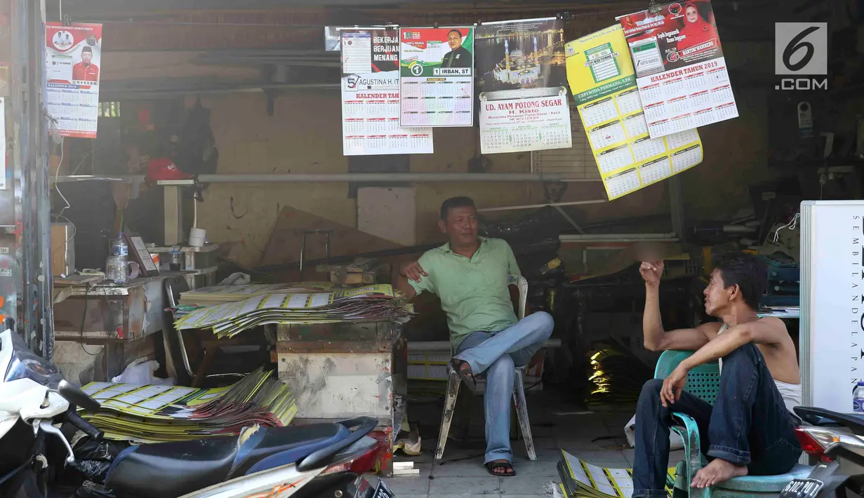 Pekerja bersantai usai membuat kalender tahun 2019 di kawasan Senen, Jakarta, Jumat (7/12). Menjelang berakhirnya tahun 2018, produksi kalender di kawasan pusat percetakan tersebut meningkat 40 persen. (Liputan6.com/Immanuel Antonius)