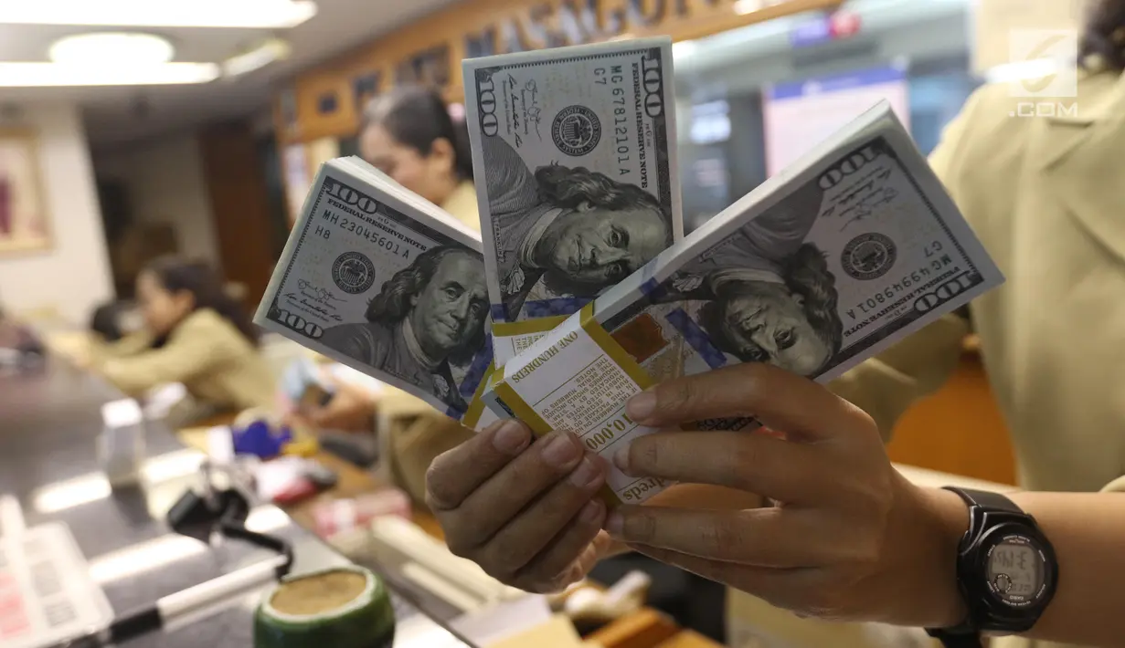 Pekerja menunjukan Dolar AS di jasa penukaran uang asing di Jakarta, Rabu (19/6/2019). Nilai tukar rupiah terhadap Dolar AS sore ini Rabu (19/6) ditutup menguat sebesar Rp 14.269 per dolar AS atau menguat 56,0 poin (0,39 persen) dari penutupan sebelumnya. (Liputan6.com/Angga Yuniar)