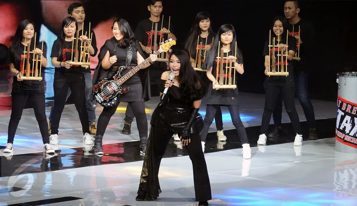 Vokalis band Kotak Tantri (tengah) tampil diiringi musik angklung di The Biggest Concert Long Live Kotak x Anggun di Studio6 Emtek City, Jakarta, Rabu (23/11). Konser ini juga bagian perayaan 12 tahun Kotak berkarya. (Liputan6.com/Helmi Fithriansyah)