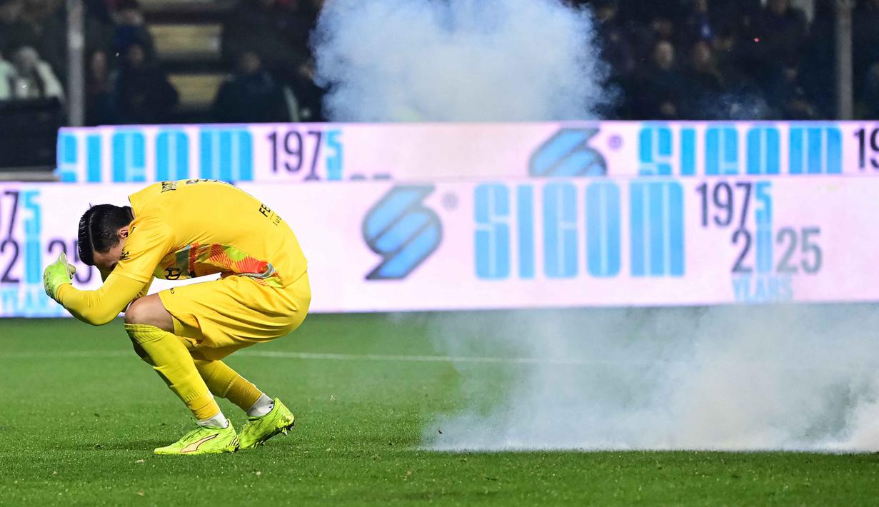 Kiper US Cremonese, Emil Audero bereaksi saat suar meledak di lapangan selama pertandingan pekan ke-23 Serie A Italia melawan Inter Milan di Stadion Giovanni Zini, Cremona, Italia utara, Minggu 1 Februari 2026 waktu setempat atau Senin (2/2/2026) dini hari WIB. (Piero CRUCIATTI/AFP)