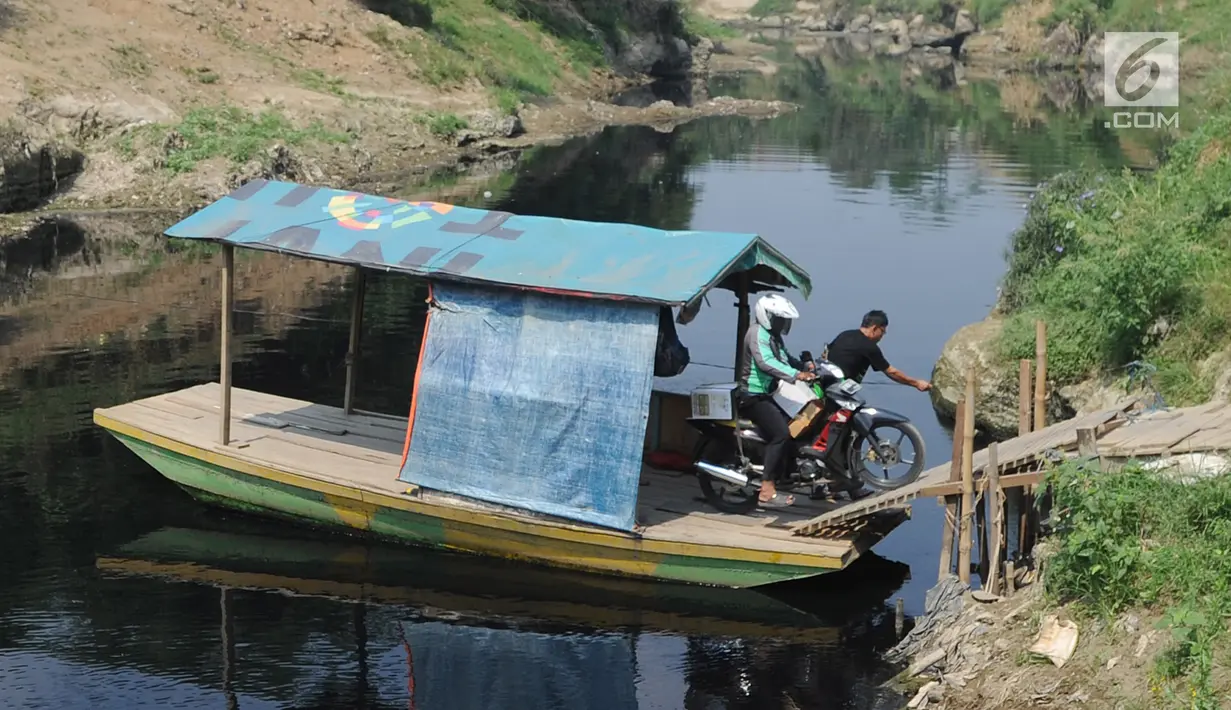 Pengendara motor menggunakan jasa penyeberangan perahu eretan di Sungai Cileungsi pebatasan Kabupaten Bogor-Kabupaten Bekasi, Bojong Kulur, Kabupaten Bogor, Jawa Barat, Selasa (23/7/2019). Perahu eretan tersebut digunakan warga sebagai jalan alternatif untuk menyeberang. (merdeka.com/Arie Basuki)