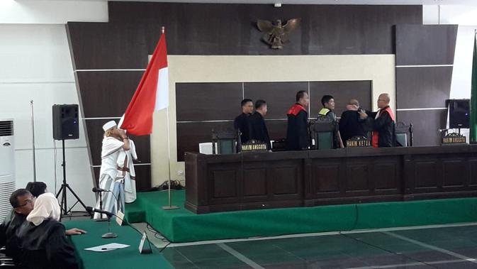 Bahar bin Smith mencium bendera merah putih usai menjalani sidang vonis di Pengadilan Negeri Bandung, Selasa (9/7/2019). (/Huyogo Simbolon)