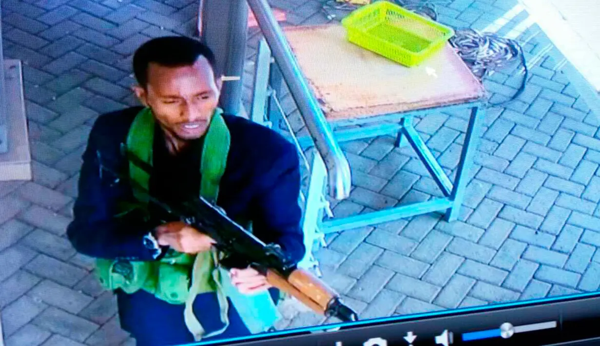 Pria bersenjata berjalan di sebuah kompleks hotel mewah di Nairobi, Kenya, Selasa (15/1). Kelompok militan Somalia, Al-Shabaab mengklaim aksi penyerangan tersebut. (Security Footage Camera via AP)