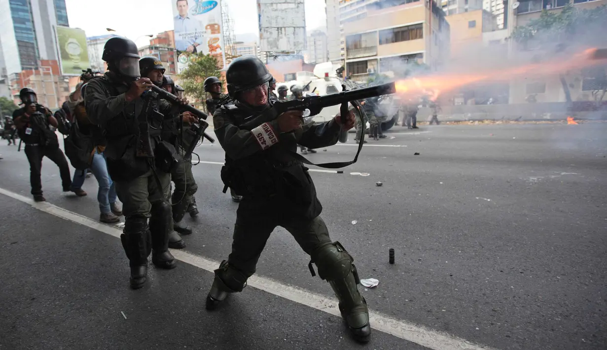 Petugas menembakan gas air mata ke arah demonstran di Caracas, Venezuela, (6/4). Bentrokan dipicu oleh keputusan kontroversial Mahkamah Agung untuk membubarkan parlemen Venezuela yang mayoritas kelompok oposisi. (AP Photo / Ariana Cubillos)