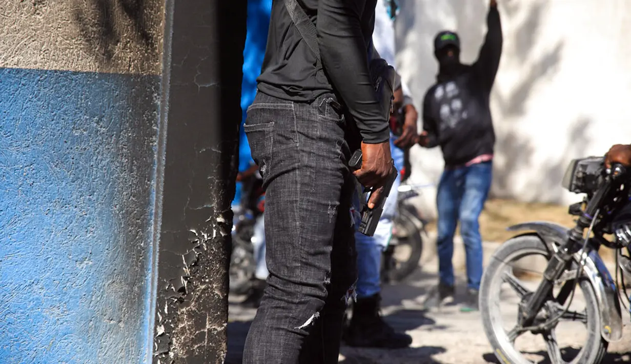 Petugas polisi membawa senjata di depan markas polisi selama protes untuk mengecam tata kelola polisi yang buruk di Port-au-Prince, Haiti, 26 Januari 2023. Pada Oktober 2022, pemerintah Henry mengimbau komunitas internasional mengirimkan pasukan keamanan multinasional untuk membantu memulihkan ketertiban. (AP Photo/Odelyn Joseph)