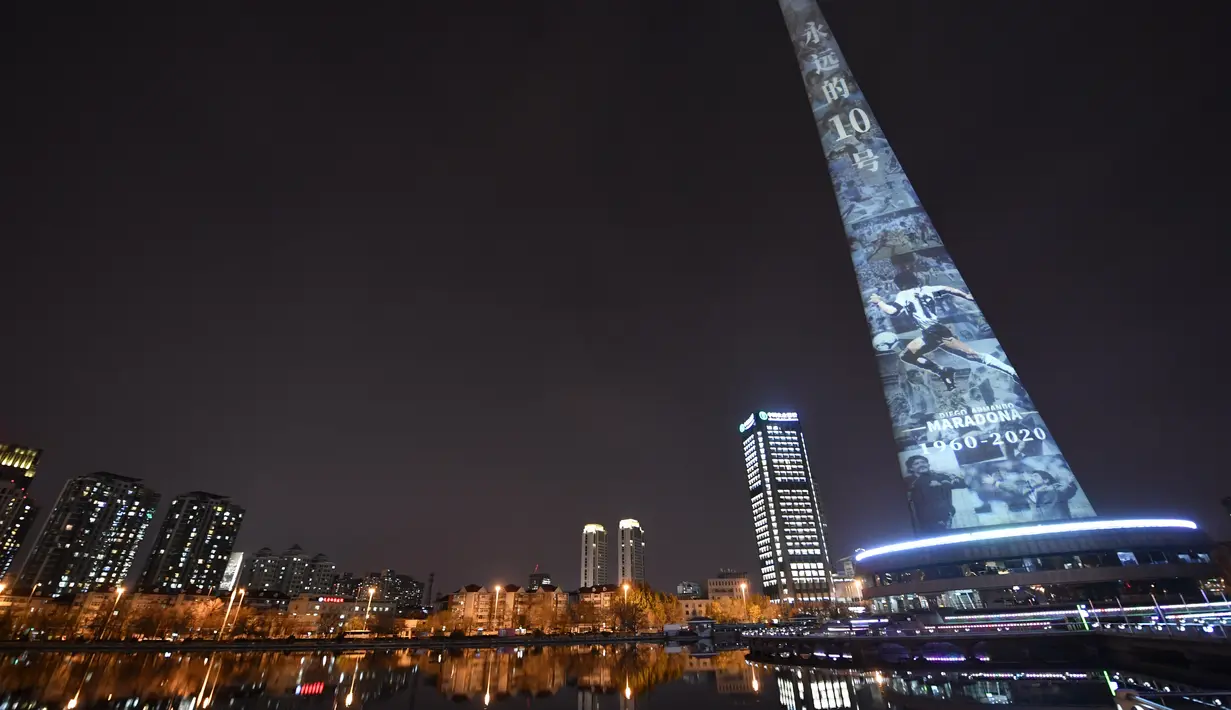 Gambar legenda sepak bola Diego Maradona diproyeksikan di Menara TV Tianjin di Kota Tianjin, China utara (26/11/2020). Maradona tutup usia di usia 60 tahun akibat serangan jantung pada Rabu (25/11). (Xinhua/Li Ran)