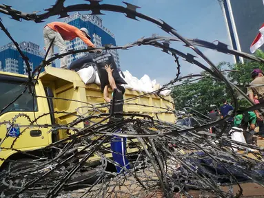 Petugas tampak mengangkut tanaman yang rusak di Taman Silang Monas, Jakarta, Jumat (22/8/14). (Liputan6.com/Faizal Fanani)